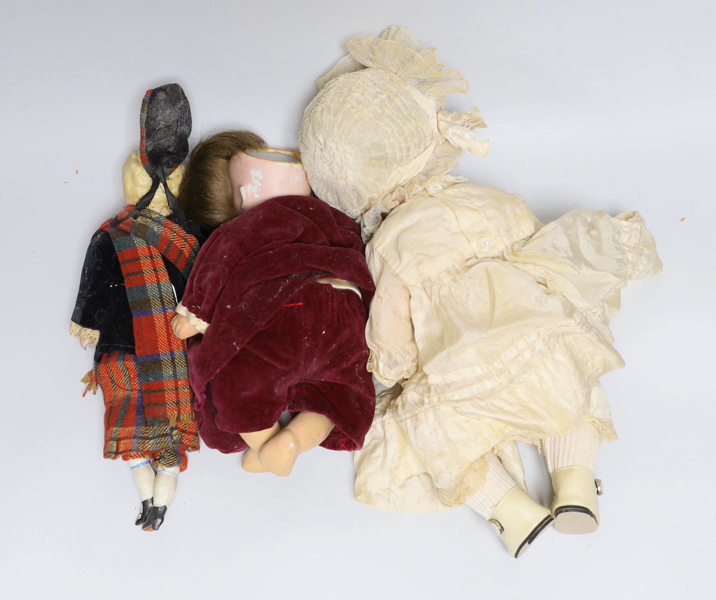 A German bent limb doll, face cracked H12in. German bent limb character baby doll H9in. bisque head Scottish doll with bisque shoes and hands H10in.